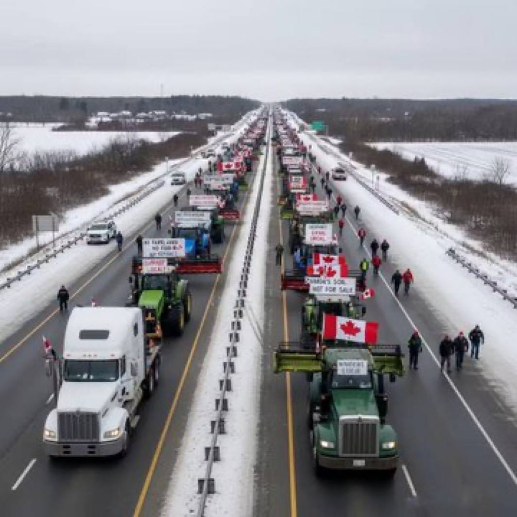 A lo largo de la carretera cubierta de nieve tuvo lugar un gran desfile de tractores, con vehículos que portaban banderas canadienses y pancartas con diversos lemas.