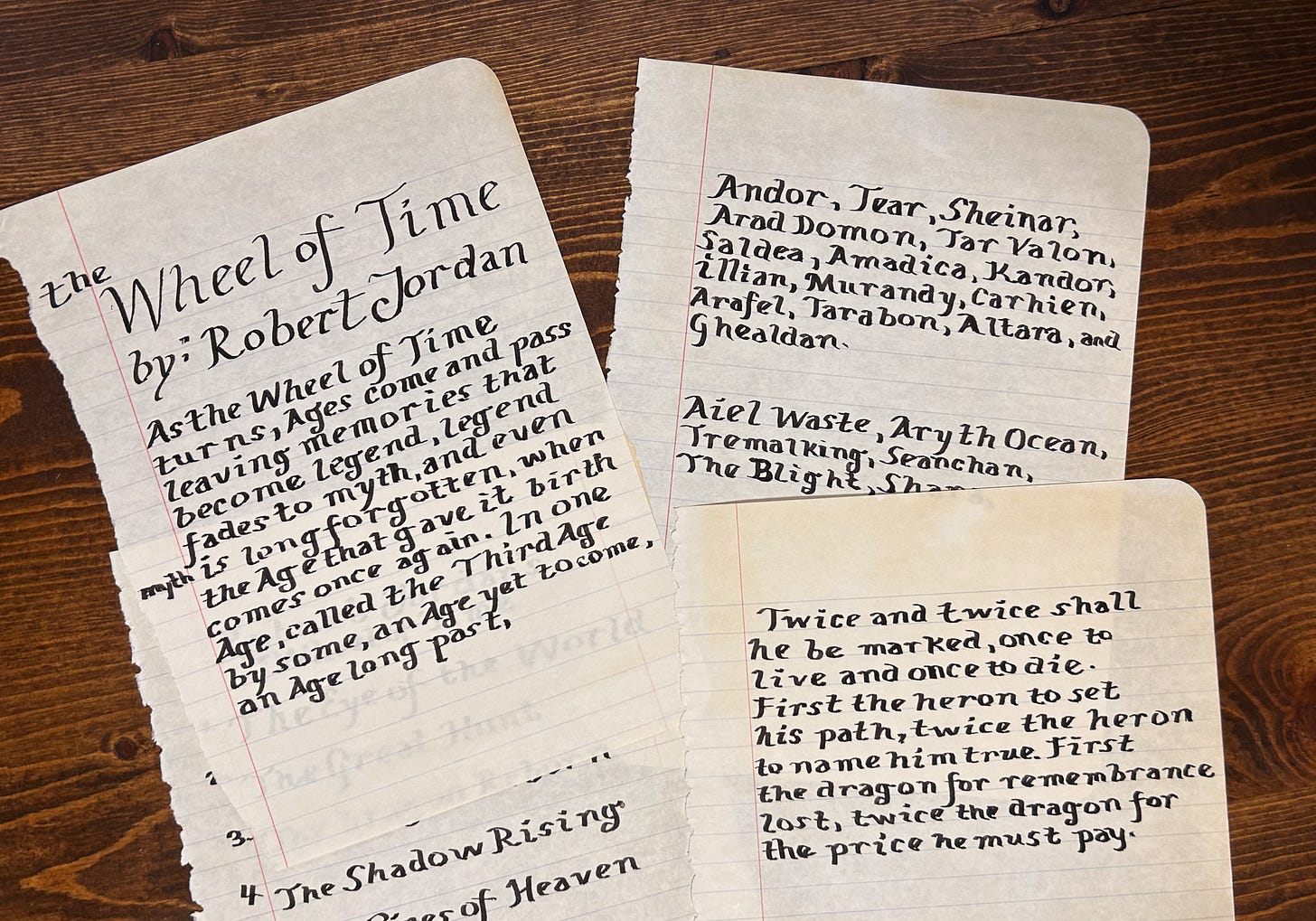 Italic calligraphy of the twice and twice prophecy, legend fades to myth quote, and lists of countries and WoT books. Pages yellowed and torn out of composition notebook.