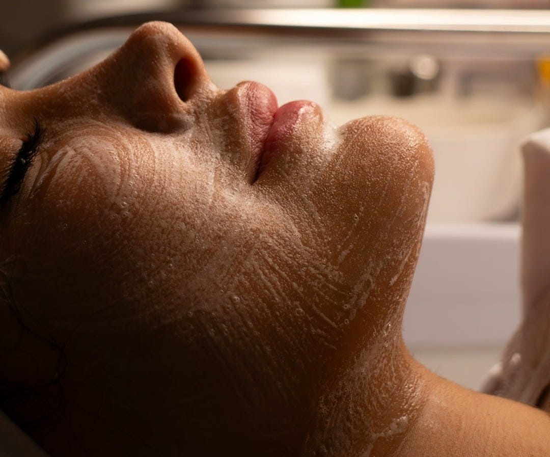 Woman's face with cleansing foam during facial treatment. Woman's face with cleansing foam during facial treatment.