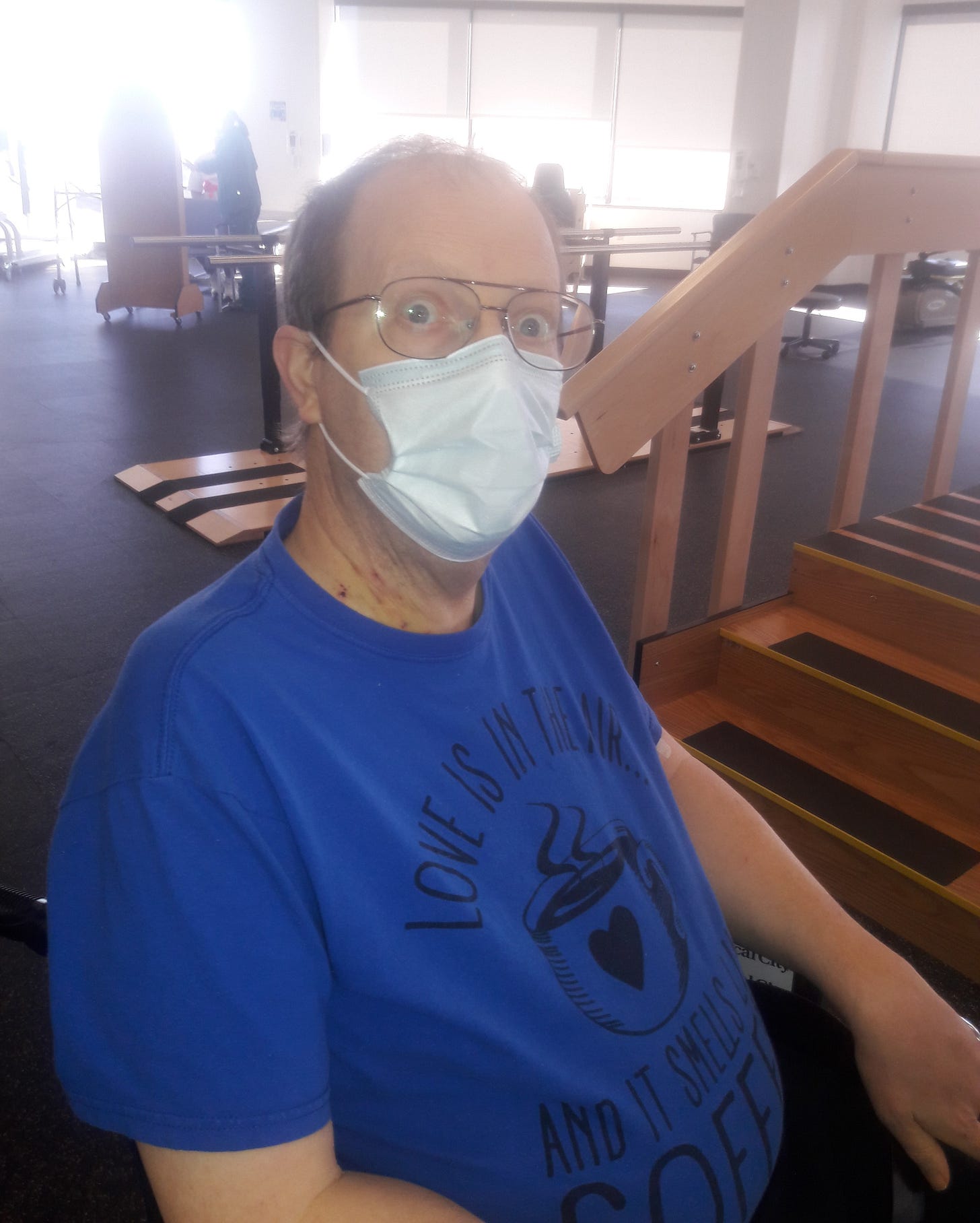 Man in chair in physical therapy room.