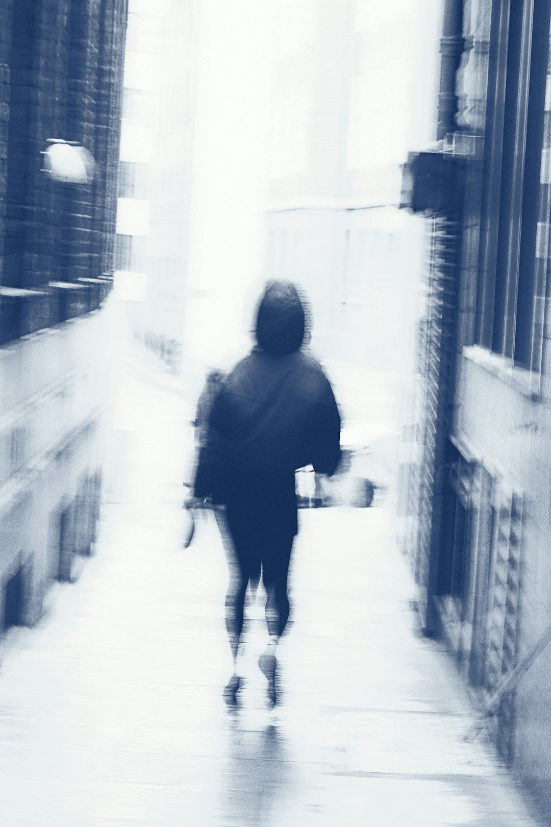 Person walks through an alleyway, in motion blur. Person walks through an alleyway, in motion blur.