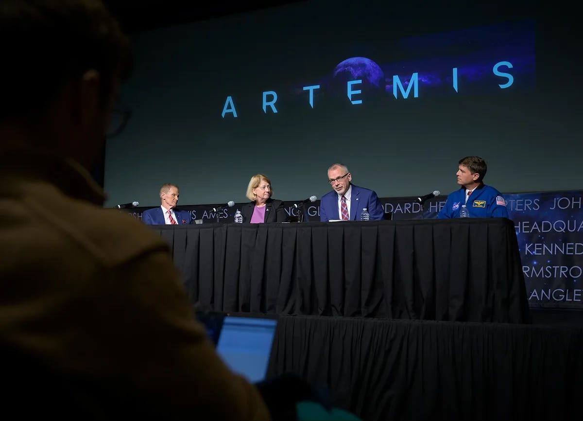 Four people giving a press conference. The word Artemis is on a screen behind them. Four people giving a press conference. The word Artemis is on a screen behind them.