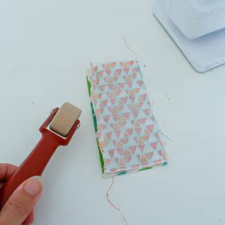 grabbing a rolling seam presser to press open a seam
