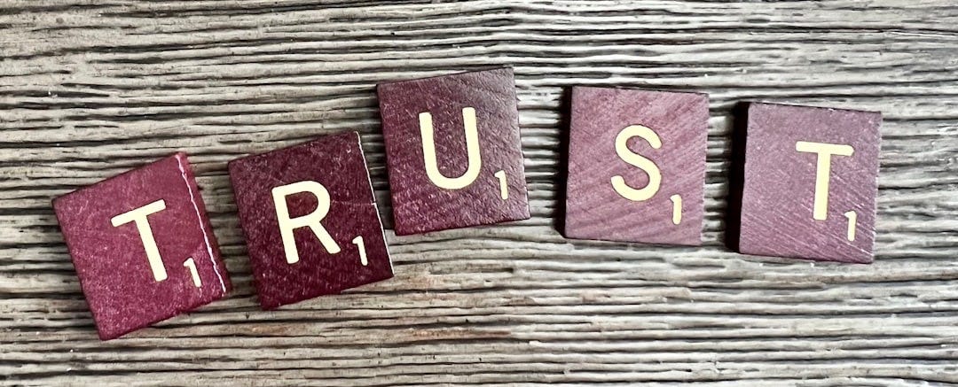 trust spelled with wooden letter blocks on a table trust spelled with wooden letter blocks on a table