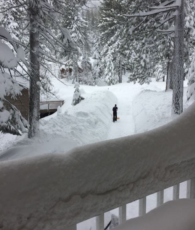man shoveling long snowy driveway