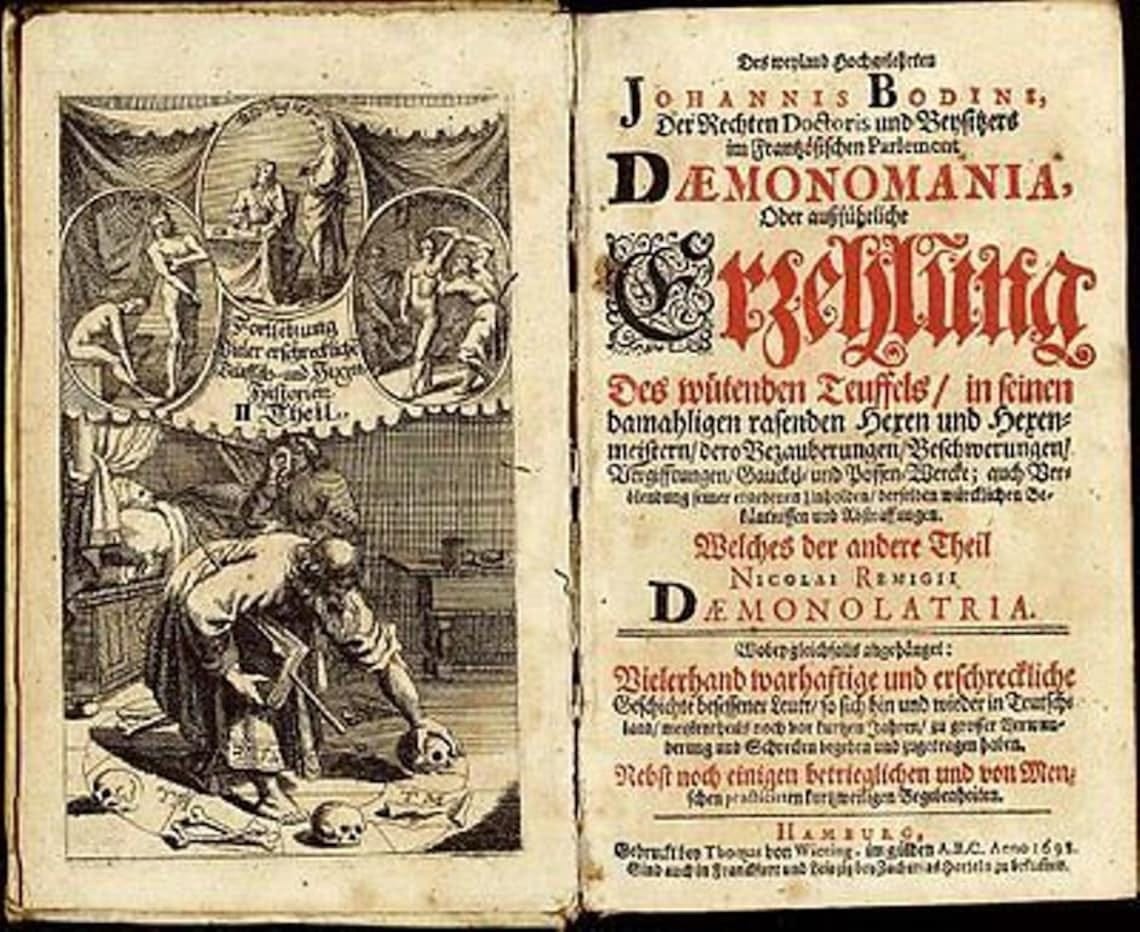 May include: An antique book with detailed illustrations and text. The left page shows small circular images of figures. The right page displays ornate text in black and red, with the title "DEMONOMANIA".