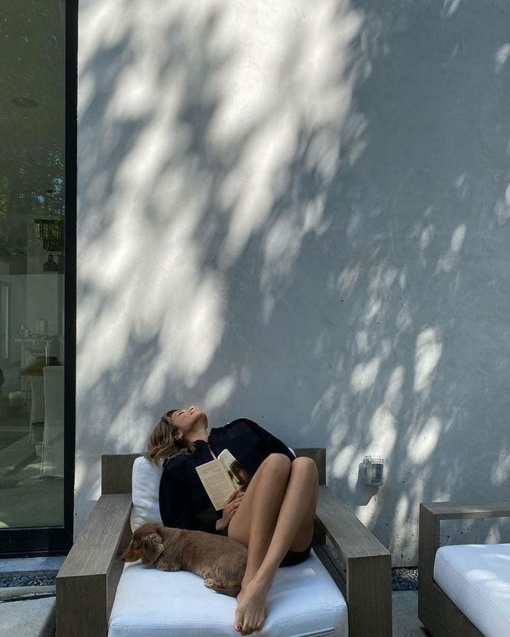 This may contain: a woman laying on top of a white couch next to a dog