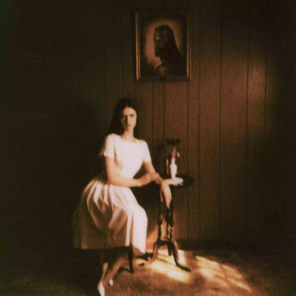 A person in a white dress sitting on a chair

Description automatically generated