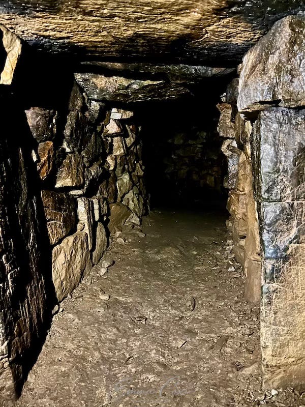 an underground passage with drystone walls and a lintel ceiling an underground passage with drystone walls and a lintel ceiling