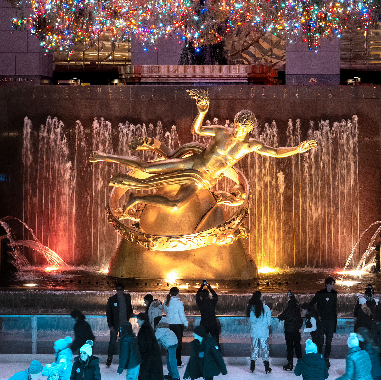 Statue of Prometheus at Rockefeller Center beneath a Christmas tree and overlooking a skating rink. Statue of Prometheus at Rockefeller Center beneath a Christmas tree and overlooking a skating rink.