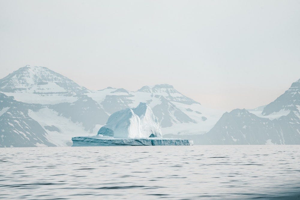 iceberg near mountain iceberg near mountain