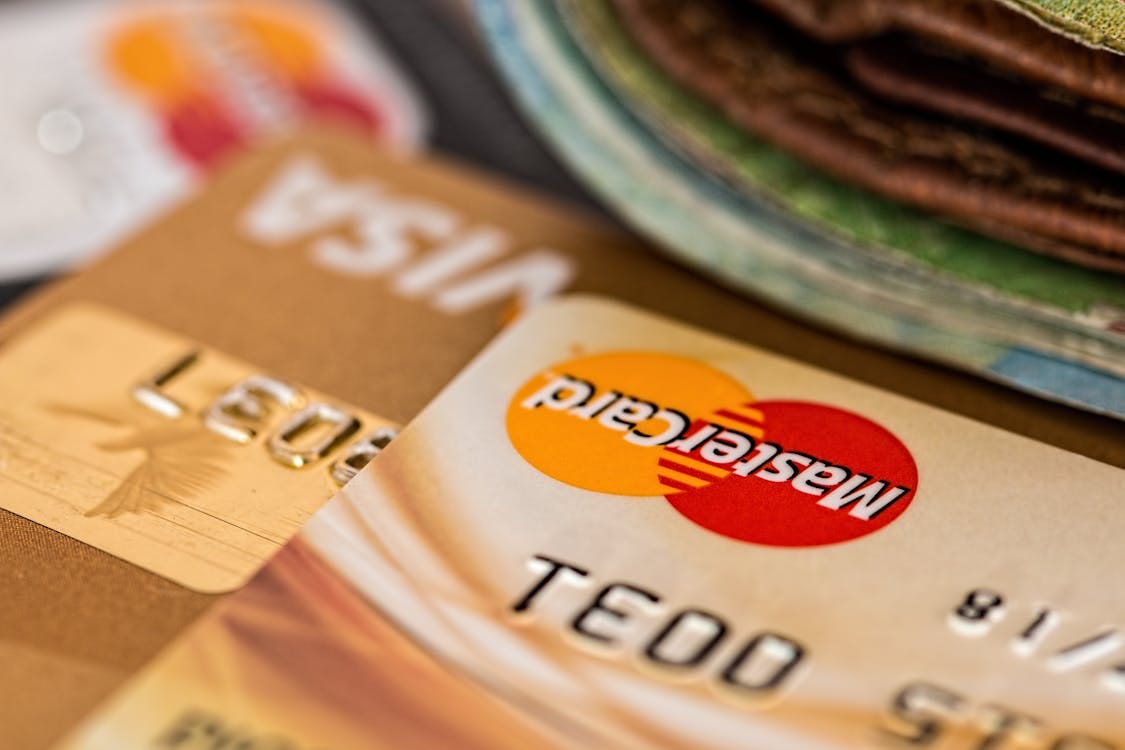 Free Macro shot of credit cards showing Visa and Mastercard logos next to a wallet, ideal for finance themes. Stock Photo