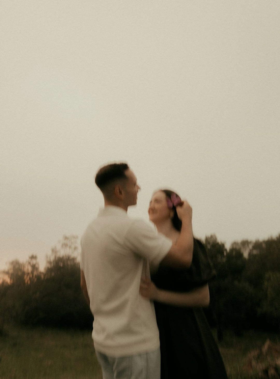 A couple embracing outdoors at dusk