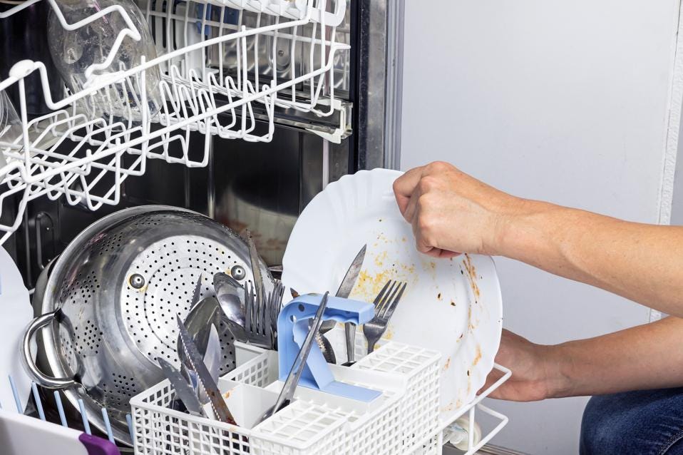 Housewife puts dirty dishes in the dishwasher