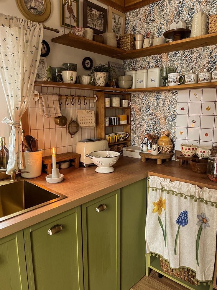 This may contain: a kitchen with green cabinets and wooden counter tops