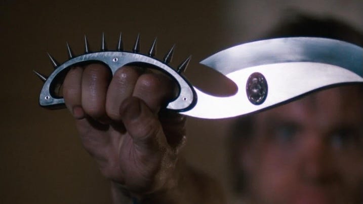 Cobra 4K UHD spiked knife close-up – Detailed shot of the Night Slasher’s curved blade with spiked knuckle grip from the Arrow Video release.