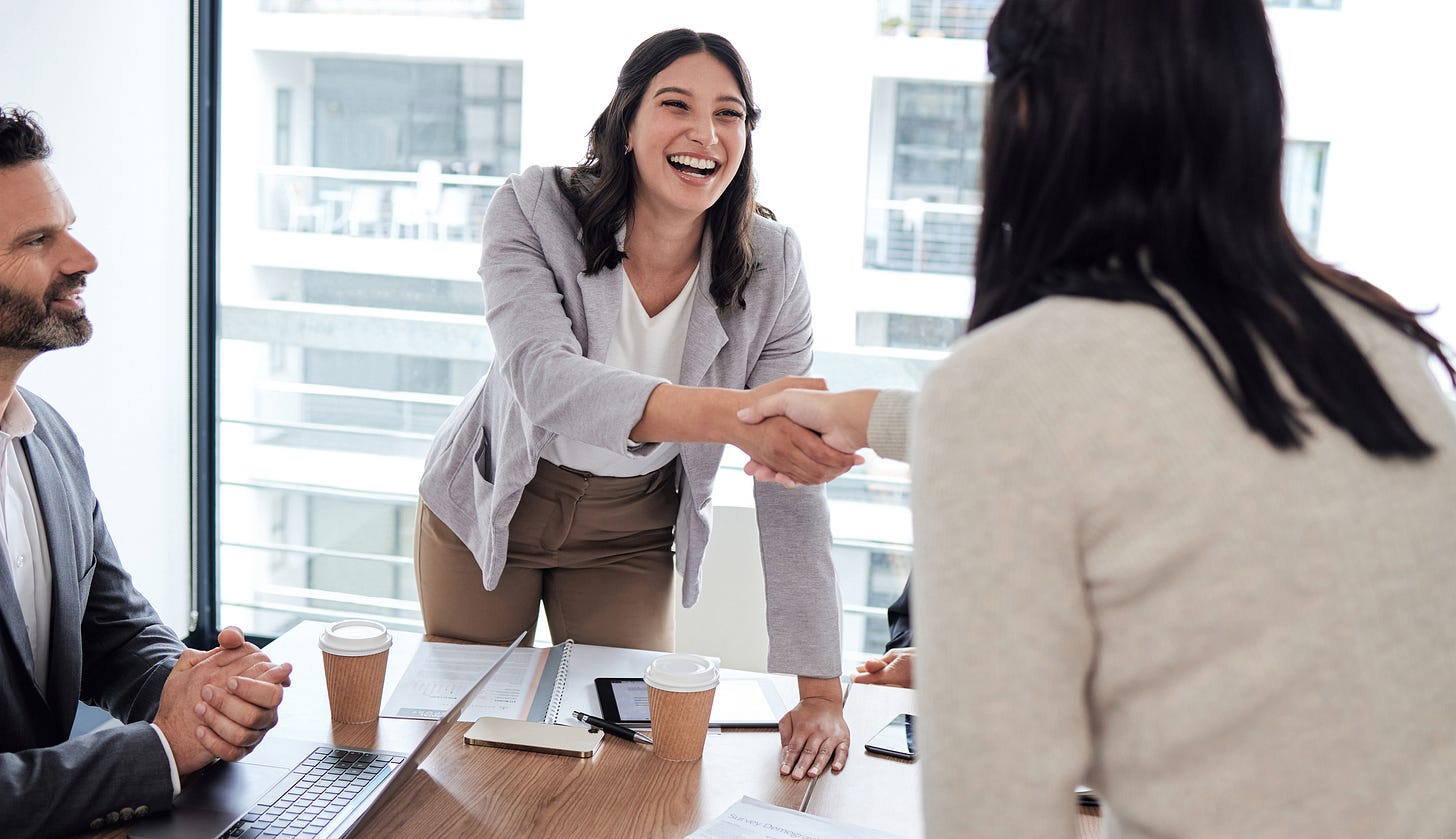 Happy employee shaking hands with teammate
