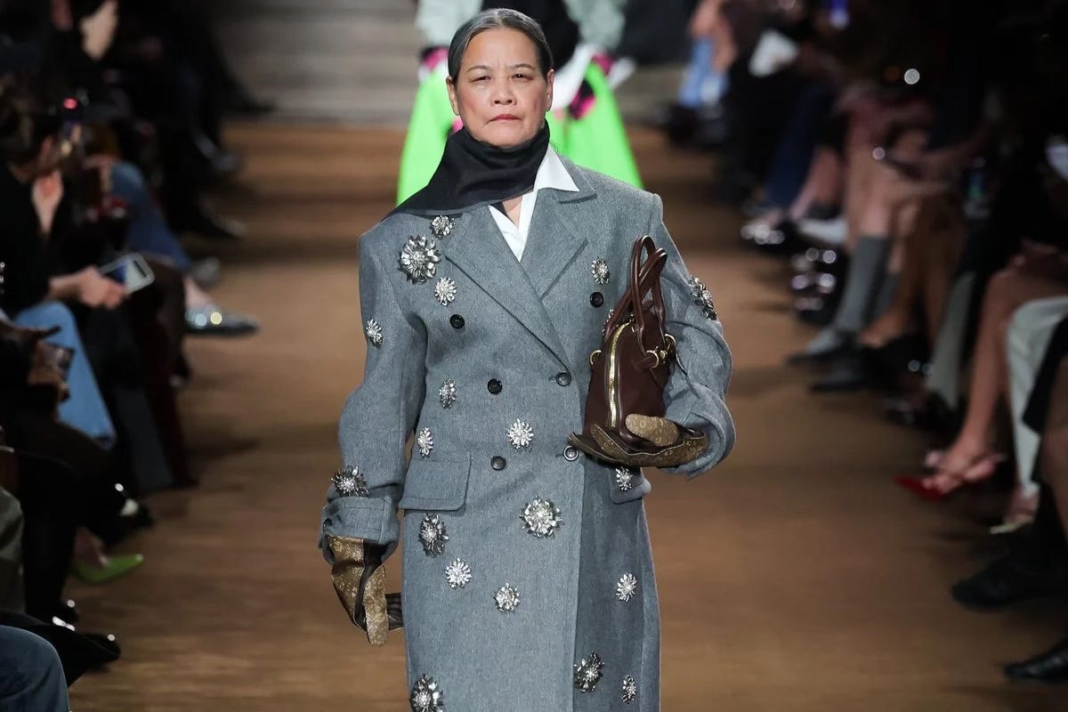 A 71-year-old retired doctor from Liuzhou, Guangxi, made her debut at the Miu Miu 2024 Autumn/Winter Paris Fashion Show, showcasing a confident charm that transcends age. (mamamia)