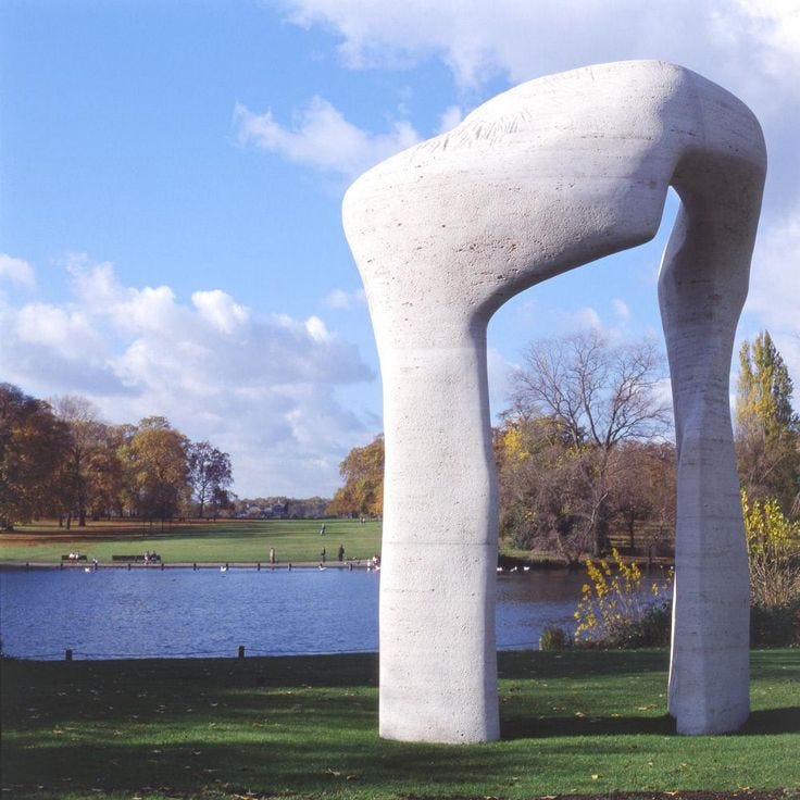 This may contain: a large white sculpture sitting on top of a lush green field next to a lake