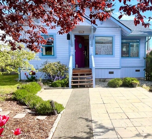 Cottage painted blue and white with a garden and paving at the front. Cottage painted blue and white with a garden and paving at the front.