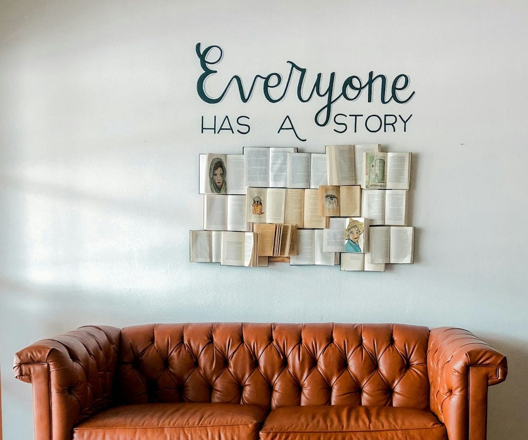 a brown leather couch sitting in front of a white wall