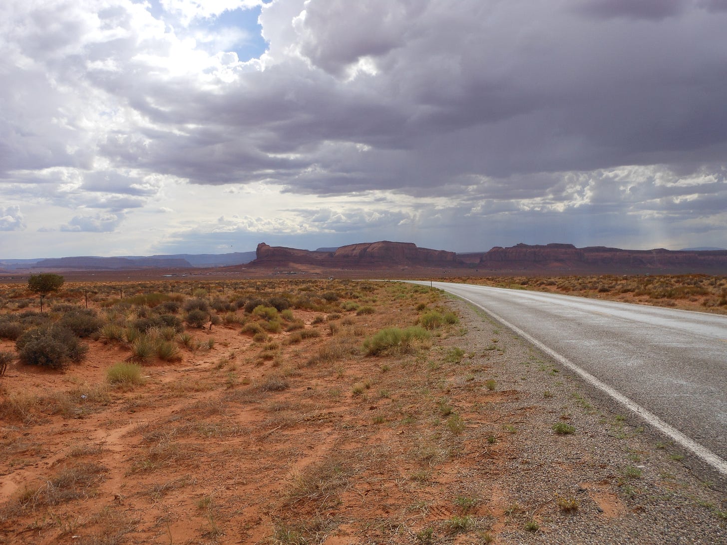An asphalt road winding through the Arizona desert.