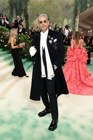 Image may contain Jeff Goldblum Person Adult Clothing Formal Wear Suit Glove Wedding Coat Accessories and Glasses