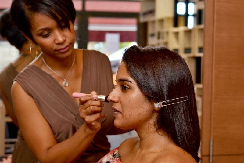 Dominique Raya applying make up on a client's face in her make up studio in Rose-Hill, Mauritius.