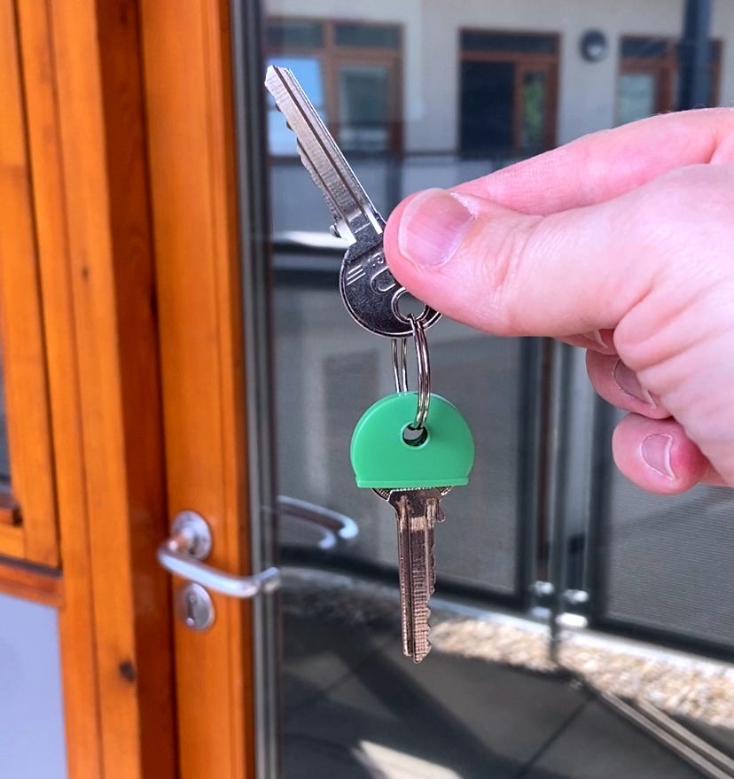 Marc from MarcoLooks holding up the key to his new studio. Two keys to be precise, both silver, but one has a fetching green cover.