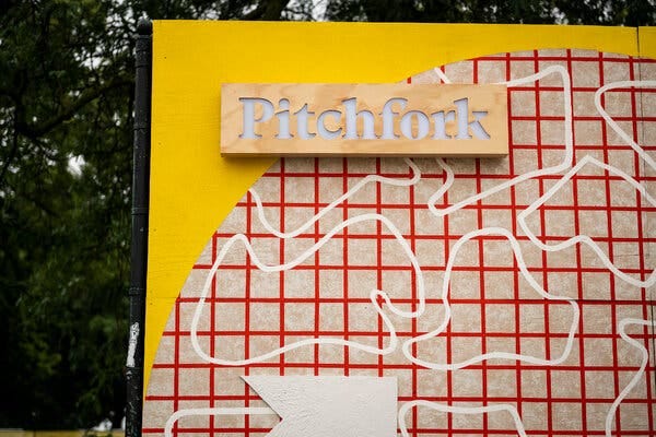 A large sign, a background for taking photos at a music festival, shows the Pitchfork name and an abstract pattern.