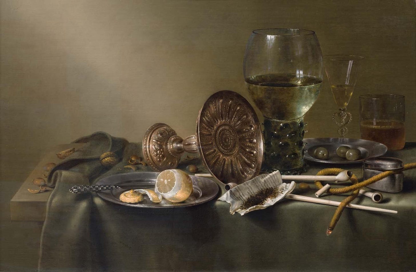 Still life showing glasses and a lemon with the tip peeled off. 