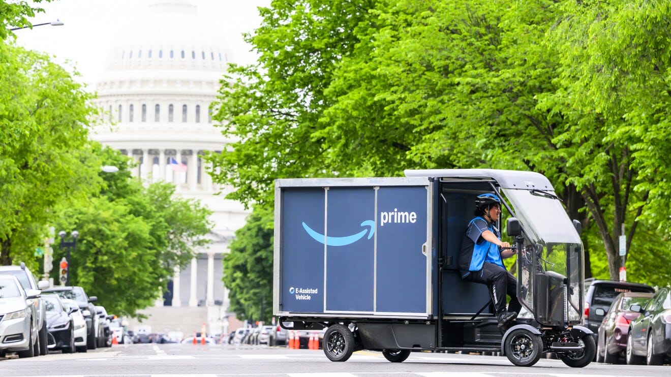 Amazon Prime delivery vehicle driving on a tree-lined street with the U.S. Capitol building in the background