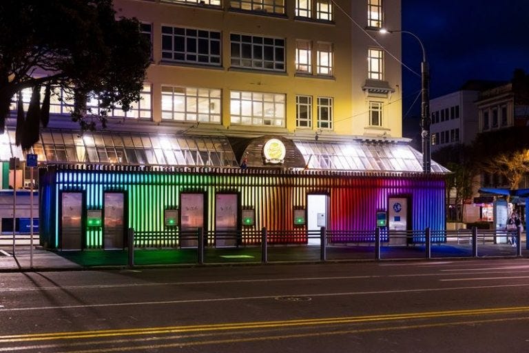 image of new toilet block at night with rainbow lighting on fully display