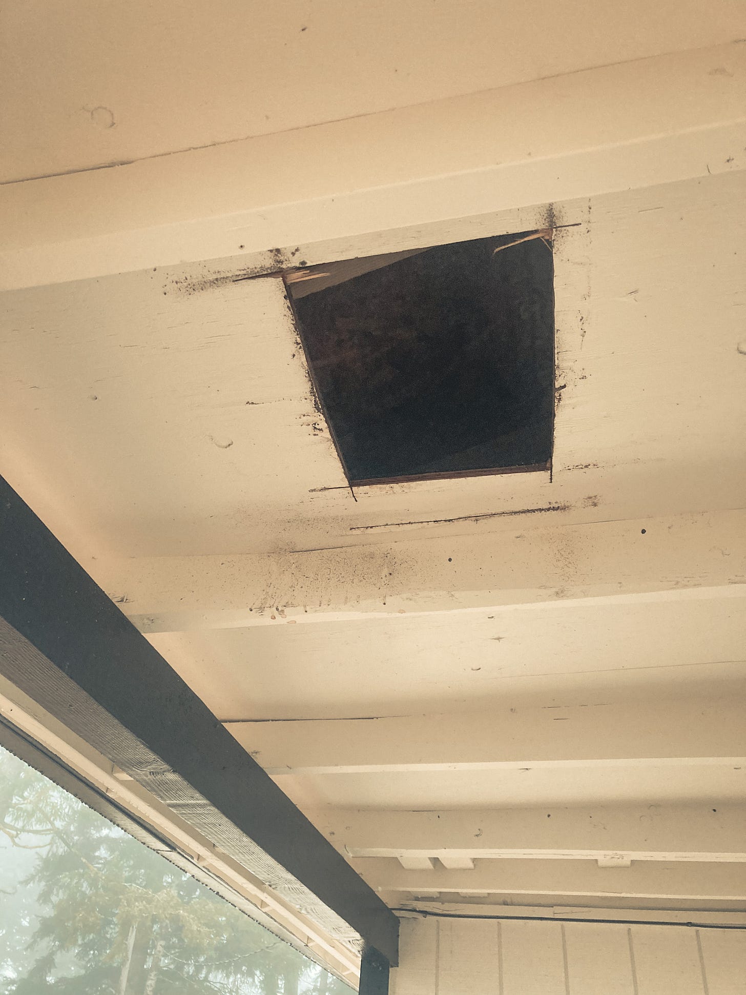 A square hole cut in the ceiling of Siloh's back porch