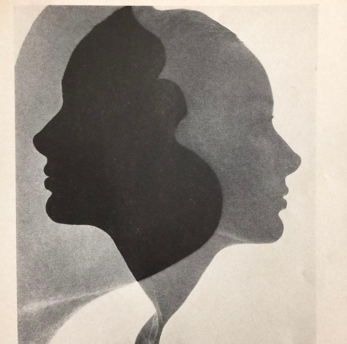 two female profiles layered on each other in black and white