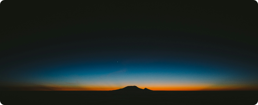 Late sunset behind the sillhouette of a mountain