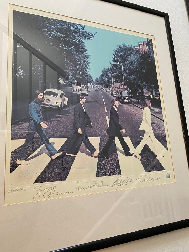 picture frames of Beatles album covers and photographs of Liam & Noel Gallagher and David Bowie.