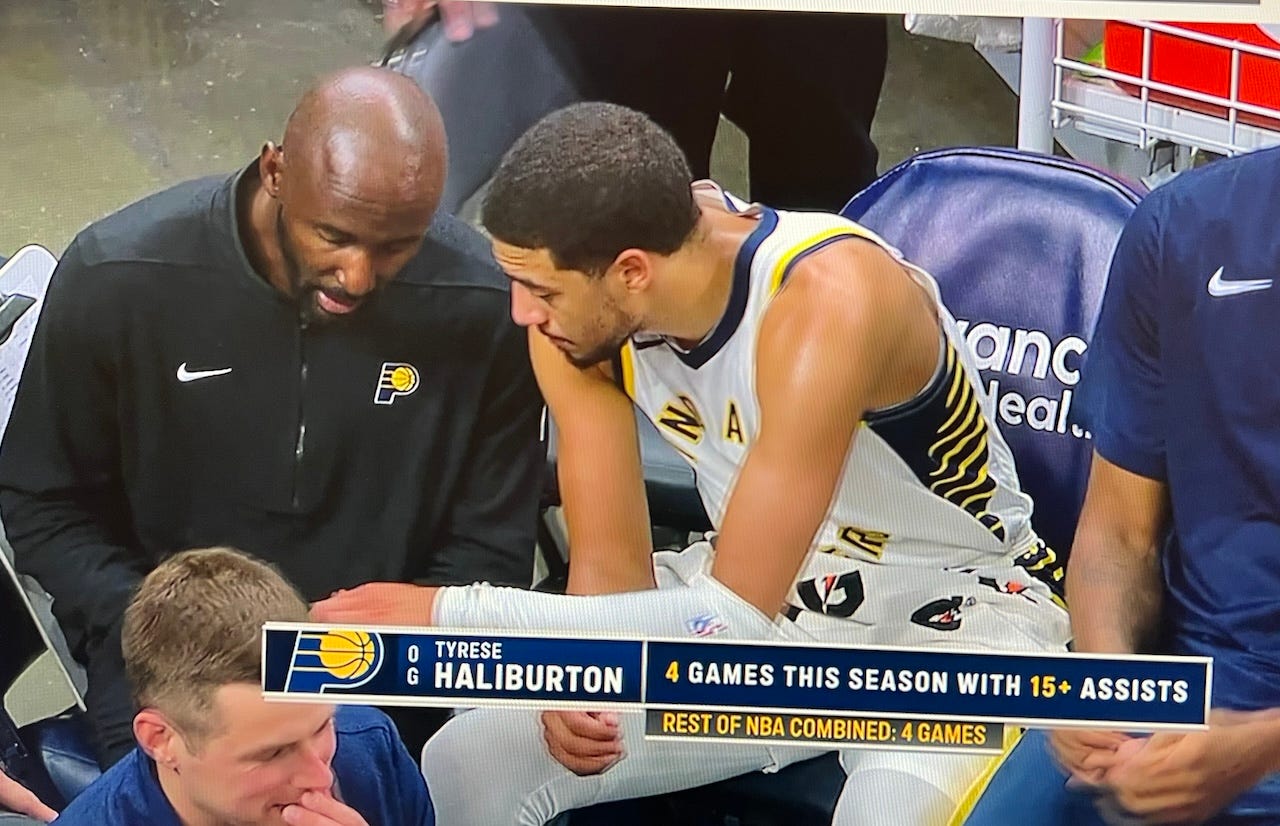 Tyrese Haliburton talks with Lloyd Pierce on the bench.