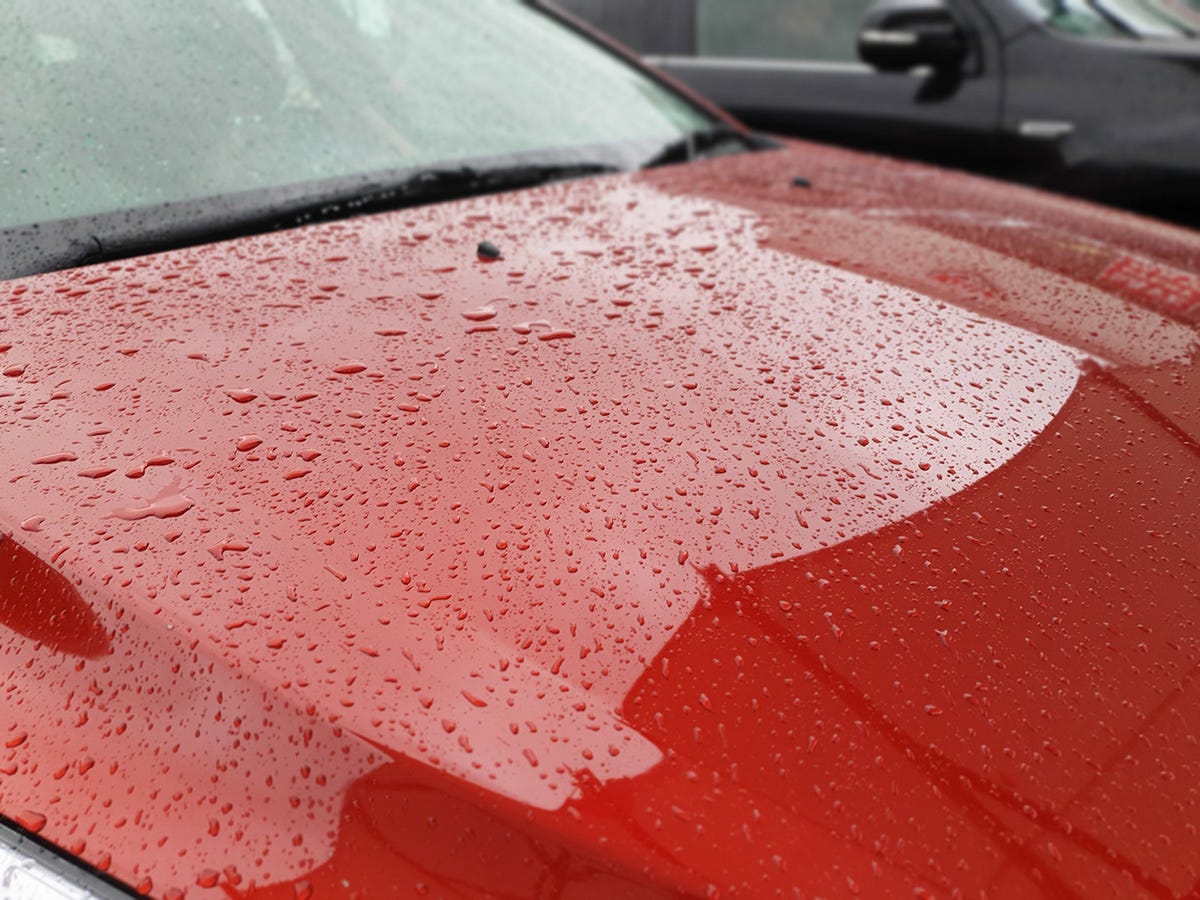 A more zoomed in pic of the raindrops on the bonnet of the red car.