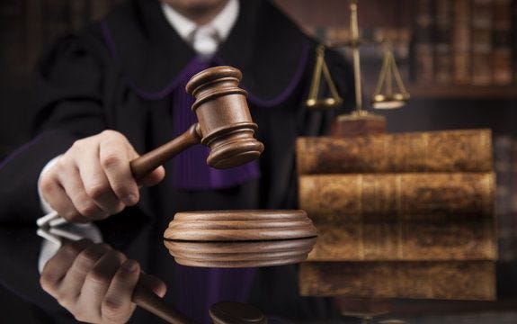 Justice and law concept, Male judge in a courtroom striking the gavel