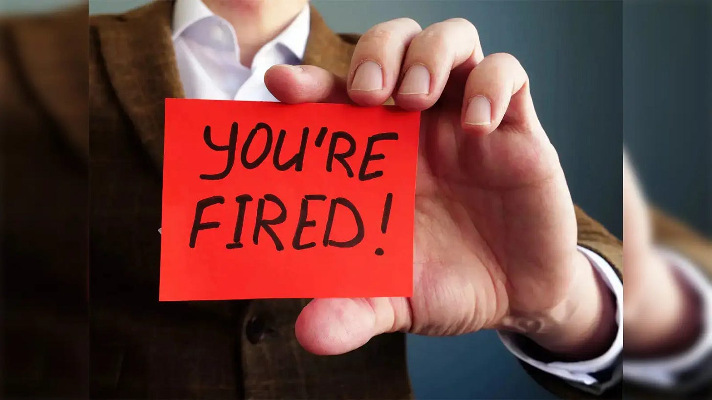 Close-up of a hand holding a red note reading ‘YOU’RE FIRED!’, symbolizing sudden job termination. Close-up of a hand holding a red note reading ‘YOU’RE FIRED!’, symbolizing sudden job termination.