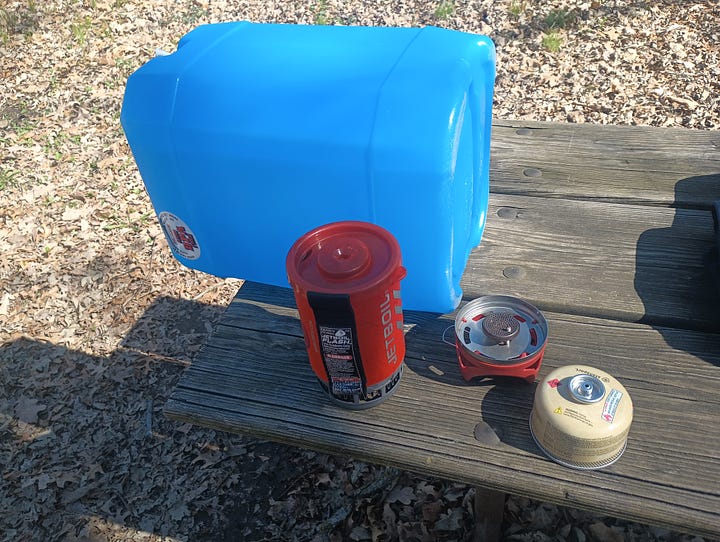 left picture is a 5 gallon water container and Jet Boil; right picture is the plastic food box with the lid flipped up