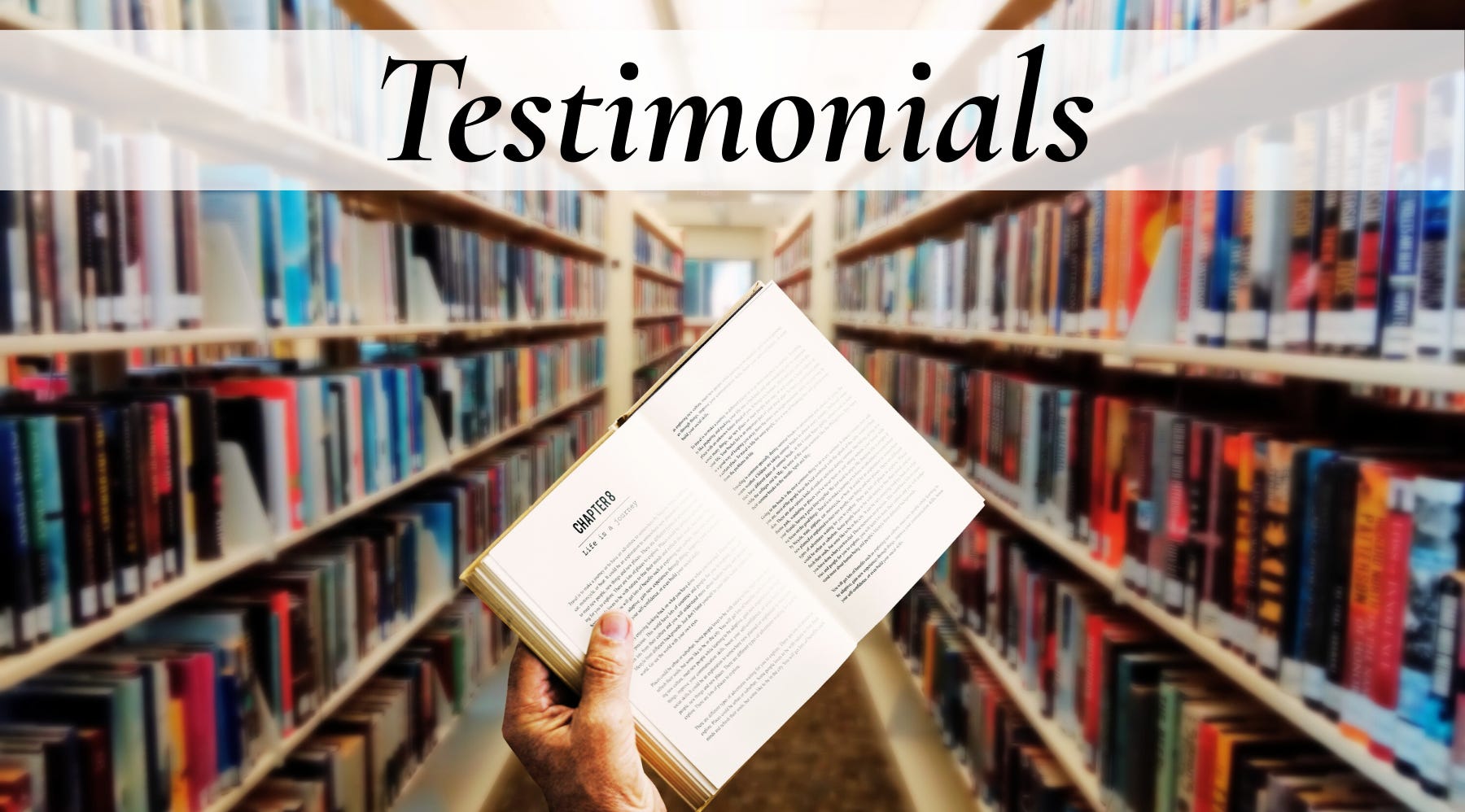 Image of someone holding a book up in a library