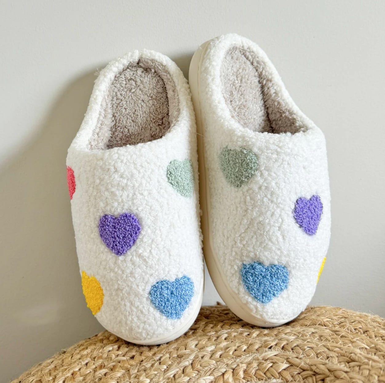 White fuzzy slippers with colorful hearts