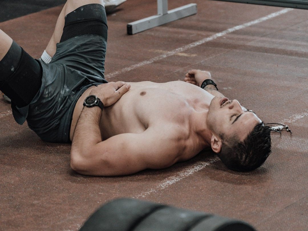 a man laying on the ground with a barbell a man laying on the ground with a barbell