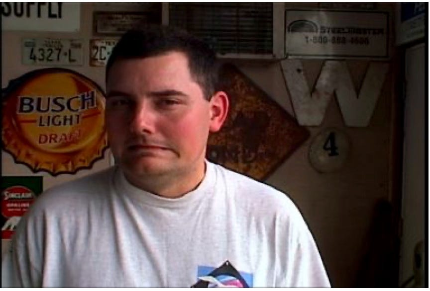 A man cringing, surrounded by beer signs.