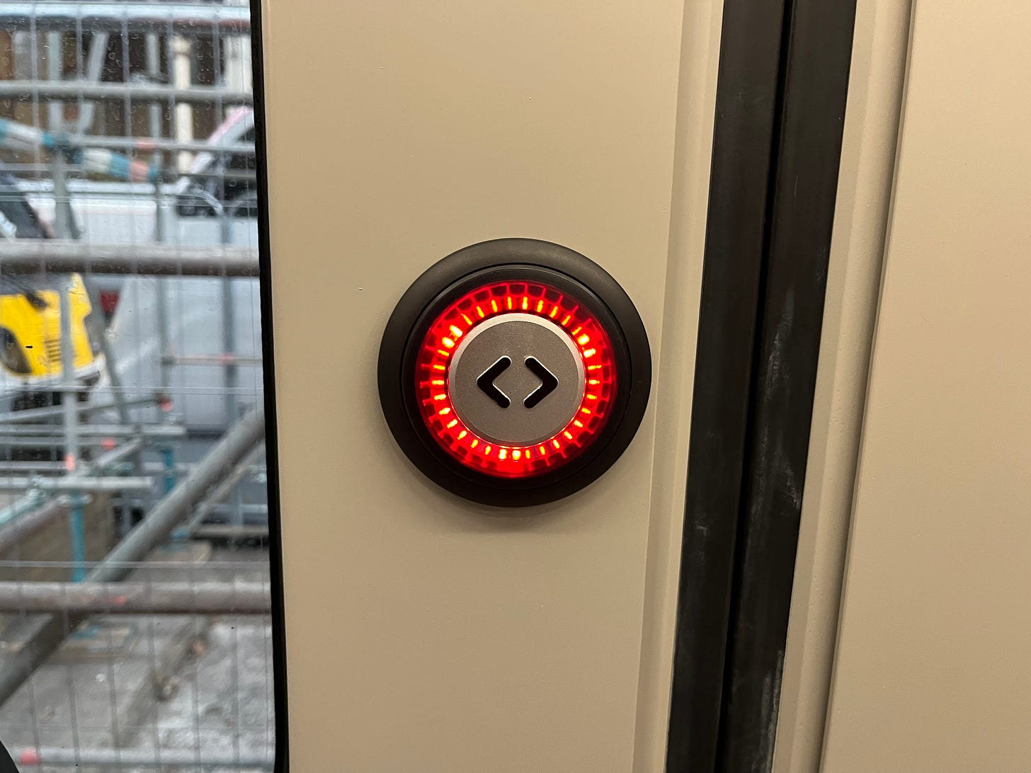 Photo of a door button on a London Overground Class 710 train, illuminated in red.