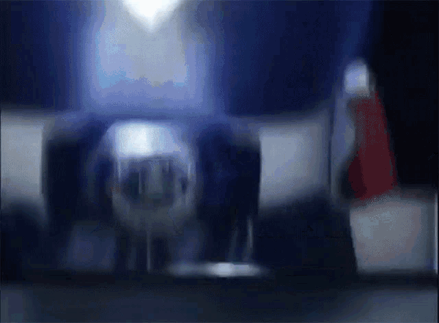 a blurry picture of a person standing in a dark room with a red carpet a blurry picture of a person standing in a dark room with a red carpet