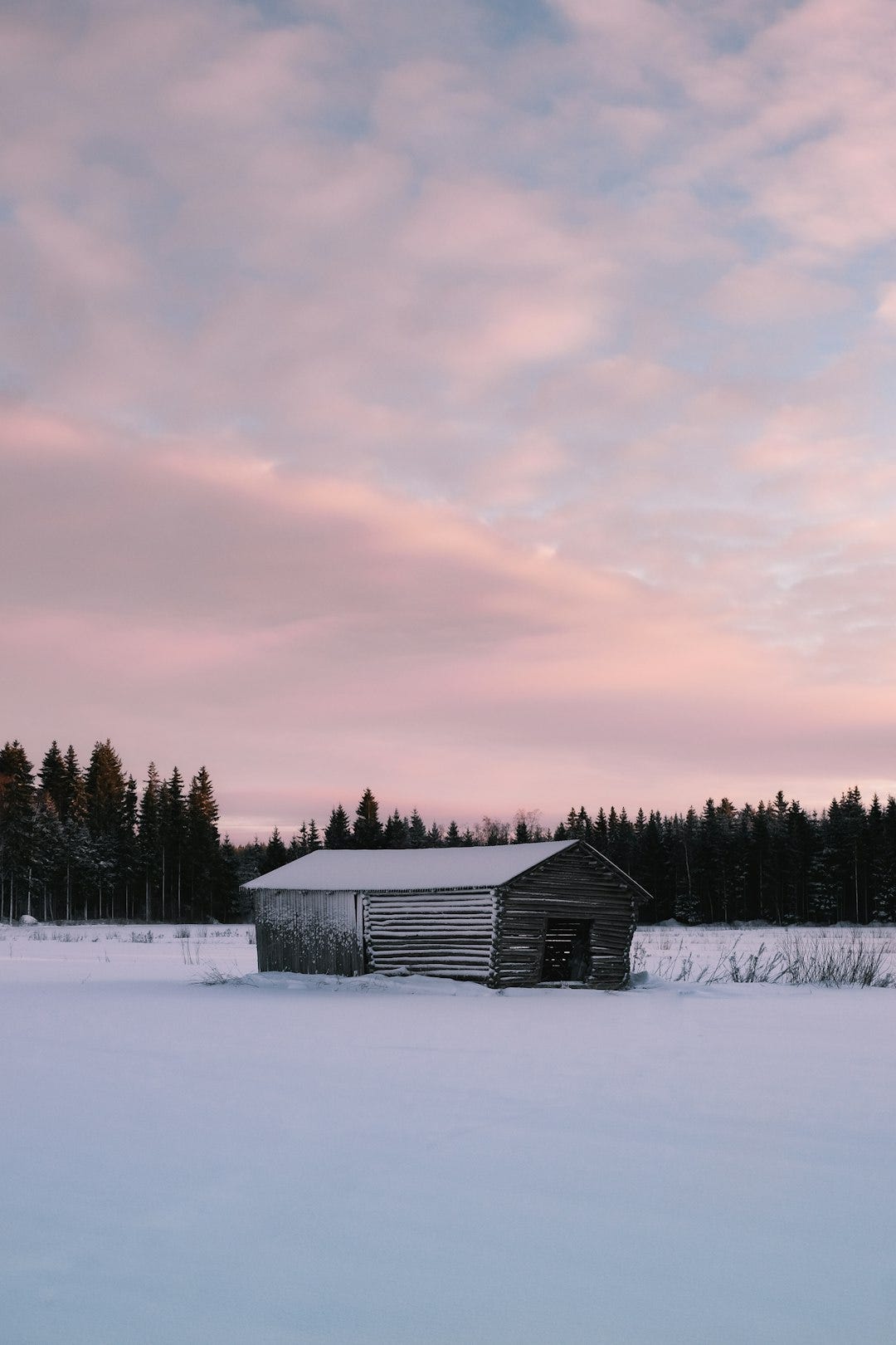 a barn in the middle of a snowy field a barn in the middle of a snowy field