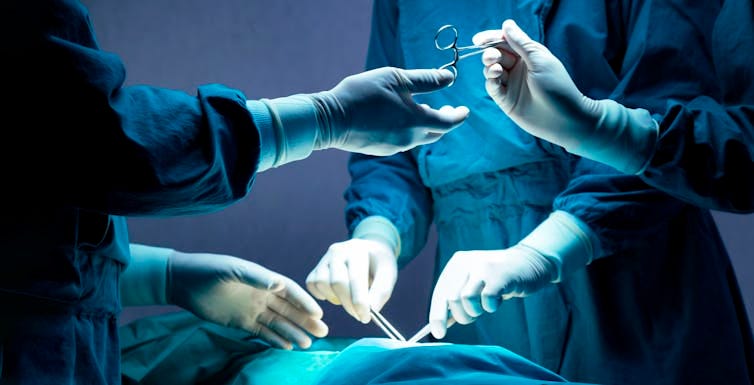 Team of surgeons operating on a patient Team of surgeons operating on a patient
